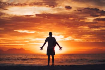 silhouette of man running on beach during sunset