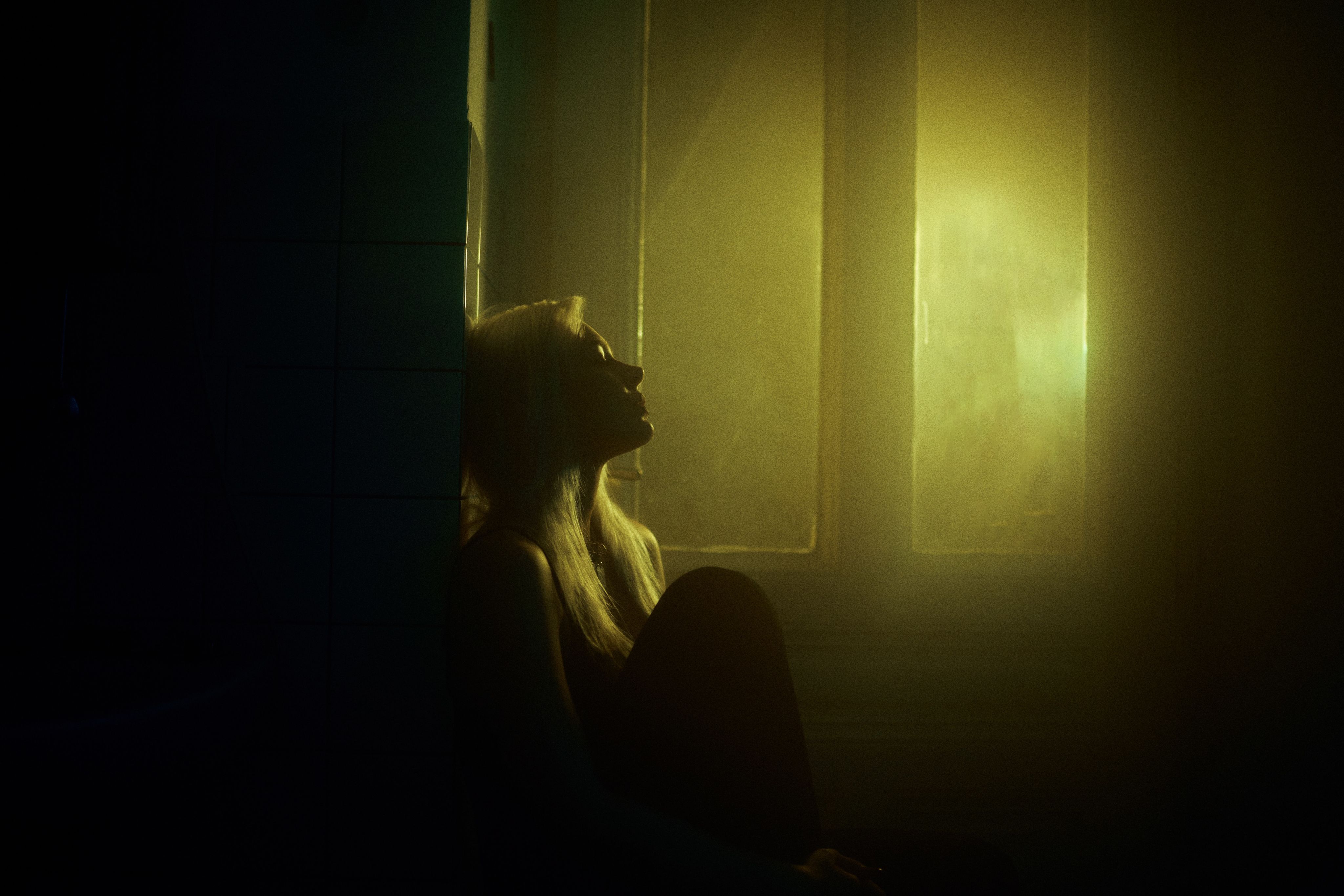 a woman sitting in a dimly lit room